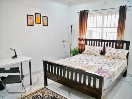 - une chambre avec un lit, une table et un bureau dans l'établissement Luxe Stays: 3BHK Fully Furnished Apt, à Hyderabad