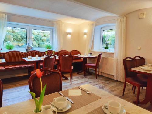 a restaurant with tables and chairs and windows at Hotel Villa Meeresgruss in Binz