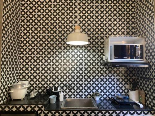 uma cozinha com um lavatório e um micro-ondas em TinyHouse w/ Pool & Alfresco Area for Guests em Bacolod