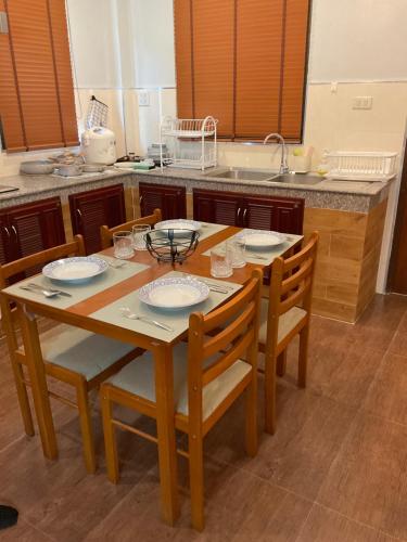 een keuken met een houten tafel met stoelen en een spoelbak bij Aonang Peace Pool Villa in Ban Khlong Haeng