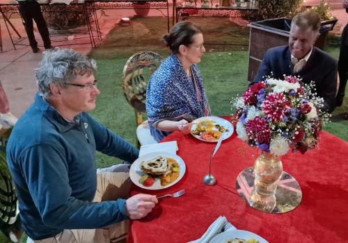 un grupo de personas sentadas en una mesa con comida en Vishal Villa, en Jaipur