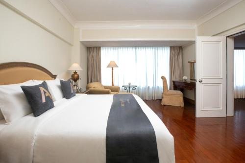 a hotel room with a large bed and a desk at Aryaduta Bandung in Bandung