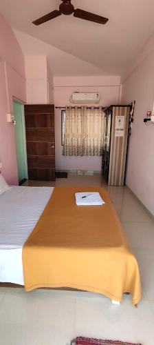 a bedroom with a large bed with a ceiling fan at Siddhi Sea View Bungalow Ganpatipule for Family in Ratnagiri