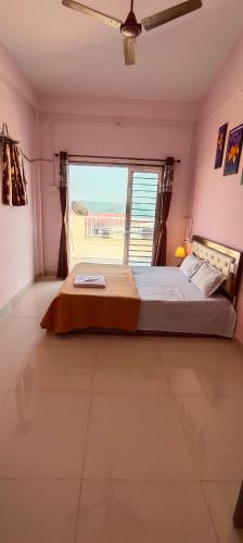 a bedroom with a large bed with a large window at Siddhi Sea View Bungalow Ganpatipule for Family in Ratnagiri