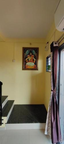 a room with a painting on the wall and a window at Siddhi Sea View Bungalow Ganpatipule for Family in Ratnagiri