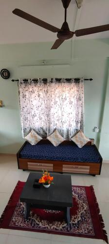 a room with a bed with a table and a window at Siddhi Sea View Bungalow Ganpatipule for Family in Ratnagiri