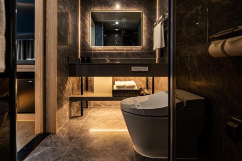 a bathroom with a sink and a toilet and a mirror at Jeju Bolton Hotel in Jeju