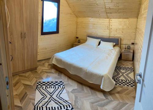 1 dormitorio con 1 cama en una cabaña de madera en Cabana Șerban, en Bughea de Jos