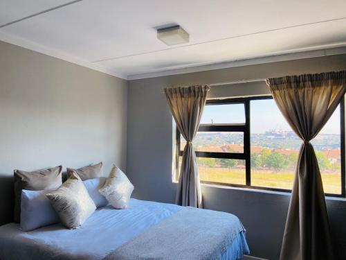 a bedroom with a bed and a large window at Gwendol’s place @ThePaddocks in Sandton