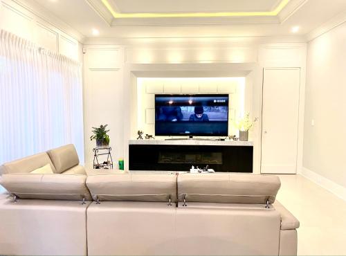 uma sala de estar com um sofá e uma televisão em Vancouver Shangrila House em Richmond
