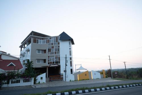 a white building on the side of a street at Reunion Solandis - Service Apartments in Udupi