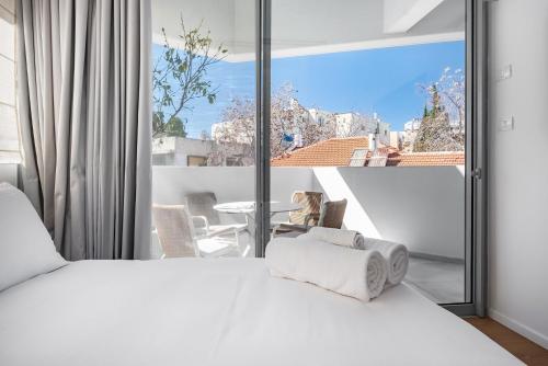 a bedroom with a white bed and a large window at KG4 LUX Apartments in Tel Aviv