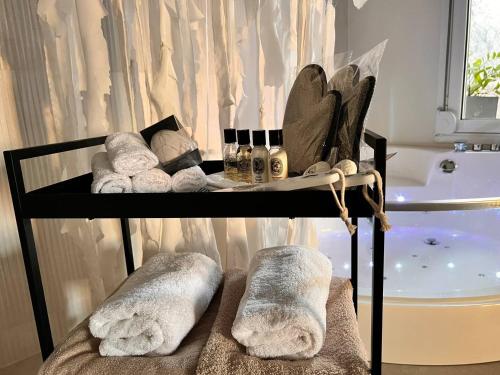 einen Handtuchhalter mit Handtüchern und einer Badewanne in der Unterkunft Perla Coco Jacuzzi Suites in Chania