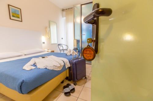 a bedroom with a bed and a door with a sign at Hotel Vannucci in Rimini