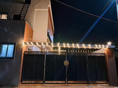 a black gate with lights on the side of a building at P Villa in Devanhalli