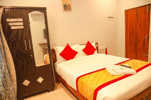 a hotel room with a bed with a phone on it at FabHotel Home Tree Service Apartment Kolathur in Chennai