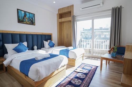 pokój hotelowy z 2 łóżkami i dużym oknem w obiekcie Tripli Hotels Ayushman Retreat w mieście Rishikesh