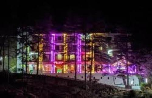 a building with purple lights on it at night at Hotel Saryal , Kullu in Kulu