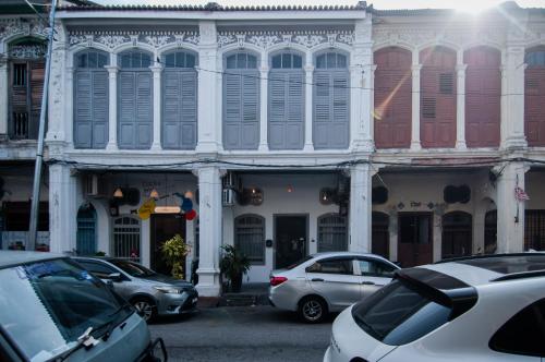un edificio con auto parcheggiate di fronte di Aayu Melayu George Town Penang a George Town