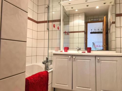 La salle de bains est pourvue d'une baignoire, d'un lavabo et d'un miroir. dans l'établissement Résidence Les Charmettes - Studio pour 2 Personnes 304, à Arc 1600