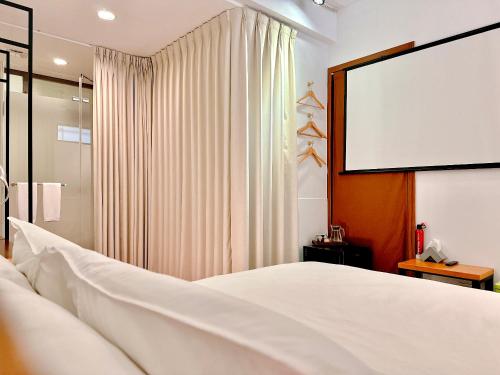um quarto com uma cama branca e um ecrã em 辣虎邸家 Love Here em Tainan