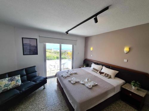 a bedroom with a large bed and a couch at Napa City Apartments in Ayia Napa