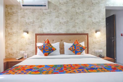 a bedroom with a large bed with colorful pillows at FabHotel Emersion Residency in Pune
