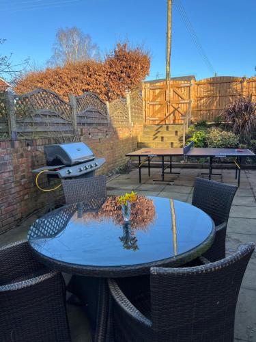 a table with chairs and a grill on a patio at The Cottage, with Superking bed & private patio in Chaddesley Corbett