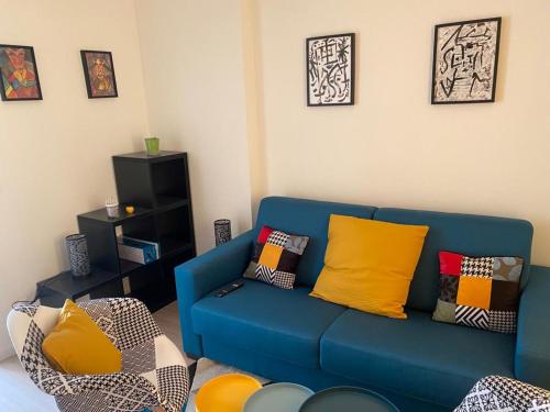 a blue couch with colorful pillows in a living room at Home concept Gace 1 - Superb apartment in Gacé in Gacé