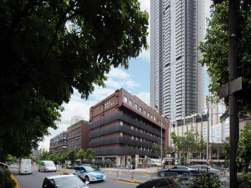 a building with cars parked in a city with tall buildings at NOA Hotel SHENZHEN LUOHU in Shenzhen