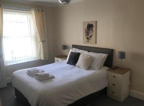 a bedroom with a large bed with towels on it at Nags Head Pub in Lampeter