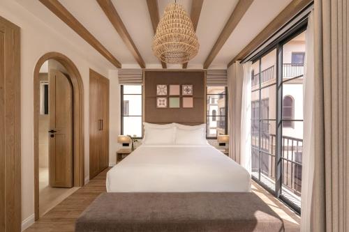 a bedroom with a bed and large windows at The Residence Resort & Villas Phu Quoc in Phu Quoc