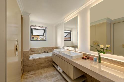 a bathroom with a sink and a bath tub at The Residence Resort & Villas Phu Quoc in Phu Quoc