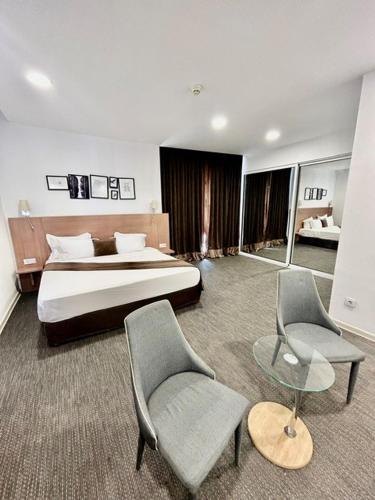 um quarto de hotel com uma cama e duas cadeiras em Vent-Dome Khaled em Orã