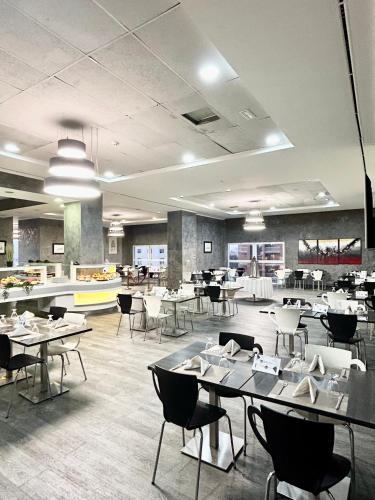 uma sala de jantar com mesas e cadeiras e uma cafetaria em Vent-Dome Khaled em Orã