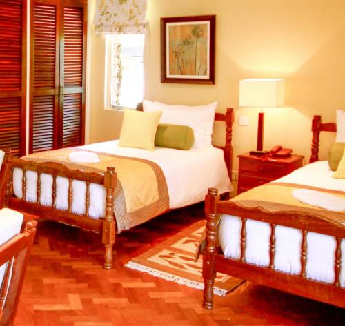 Mweiga的住宿－阿伯德爾鄉村俱樂部酒店，一间卧室设有两张床和窗户。
