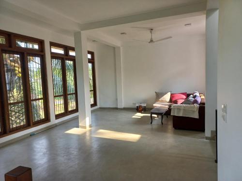 a living room with a couch and some windows at Villa paddy feild in Hiripitiya