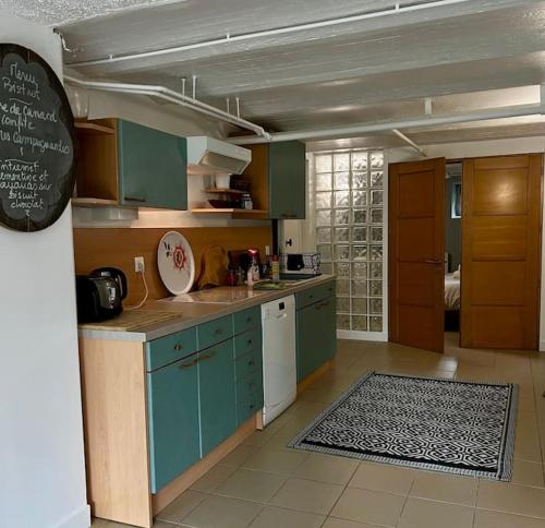 une cuisine avec des armoires vertes et un tableau noir au mur dans l'établissement Bucolique Rez-de-jardin, 4 pers, proche Disney, à Thorigny-sur-Marne
