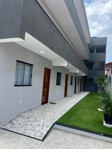 アハイアウ・ド・カボにあるArraial do Cabo - Blue View Lofts Praia Grande 03の緑の芝生のある中庭のある建物