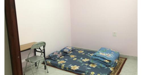 ein kleines Schlafzimmer mit einem Bett und einem Stuhl in der Unterkunft Thảo Nguyên Homestay in Lạng Sơn