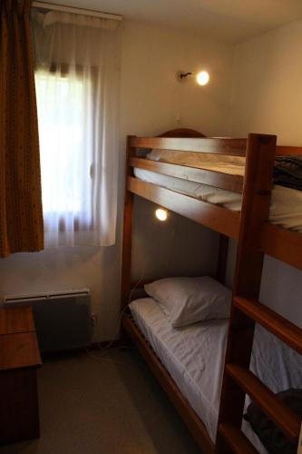 une chambre avec deux lits superposés et une fenêtre dans l'établissement Les Chalets De Superd Dauphinelle - 2 Pièces pour 4 Personnes MAE-8134, à Saint-Étienne-en-Dévoluy
