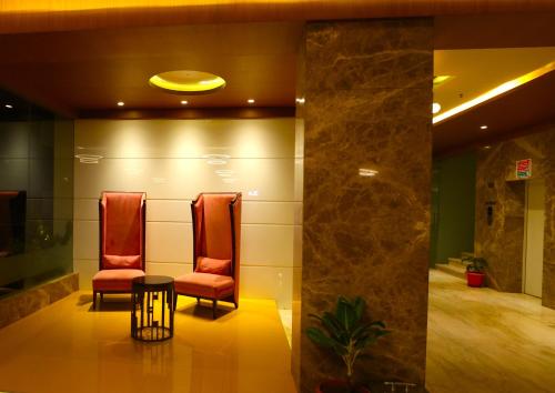 a waiting room with two chairs and a table at Sai International Hotel in Dāvangere