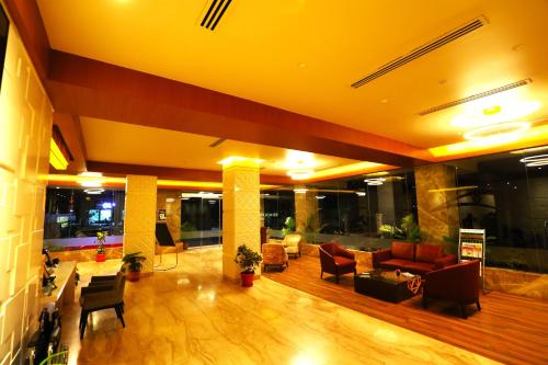 a lobby with couches and chairs in a building at Sai International Hotel in Dāvangere