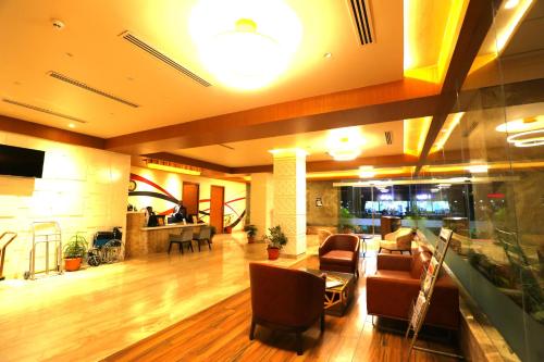 a lobby with chairs and a table in a building at Sai International Hotel in Dāvangere