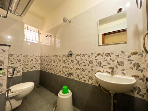 a bathroom with a sink and a toilet at Sai Manyata Inn, Bangalore in Bangalore