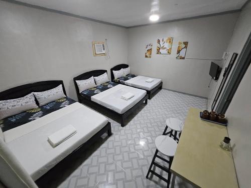 a room with two beds and a table and chairs at Madid's Inn Beach Resort in Boracay