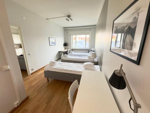 Kleines Zimmer mit 2 Betten und einem Tisch in der Unterkunft Kotimaailma Apartments Kamppi - 1BR with key code in the city center in Helsinki