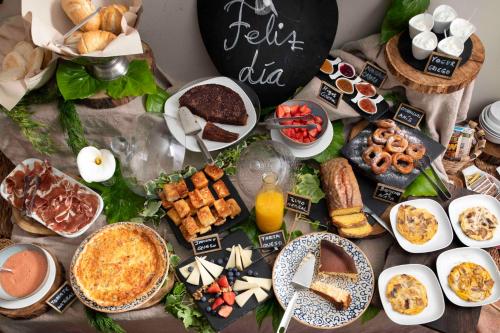 a table topped with lots of different types of food at Hotel La Corte de Lugás in Villaviciosa