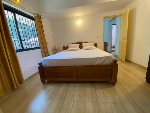 a bedroom with a bed and a large window at Apricot BH6 in Marmagao