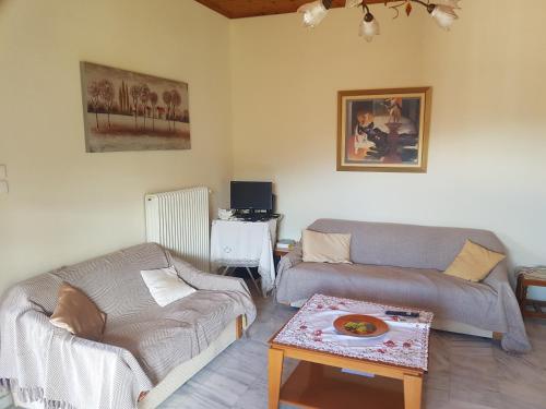 a living room with a couch and a table at Rantos P. Cottage in Dragotiná